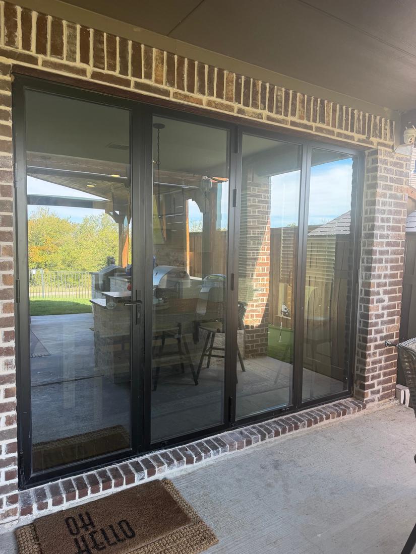 Back patio after: custom black bifold glass door in brick opening