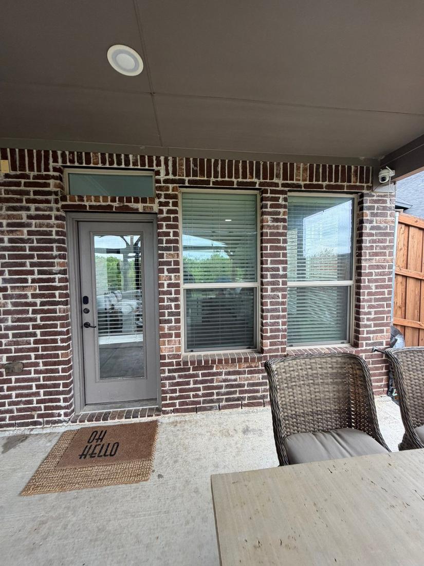 Back patio before: single door and two windows in brick wall