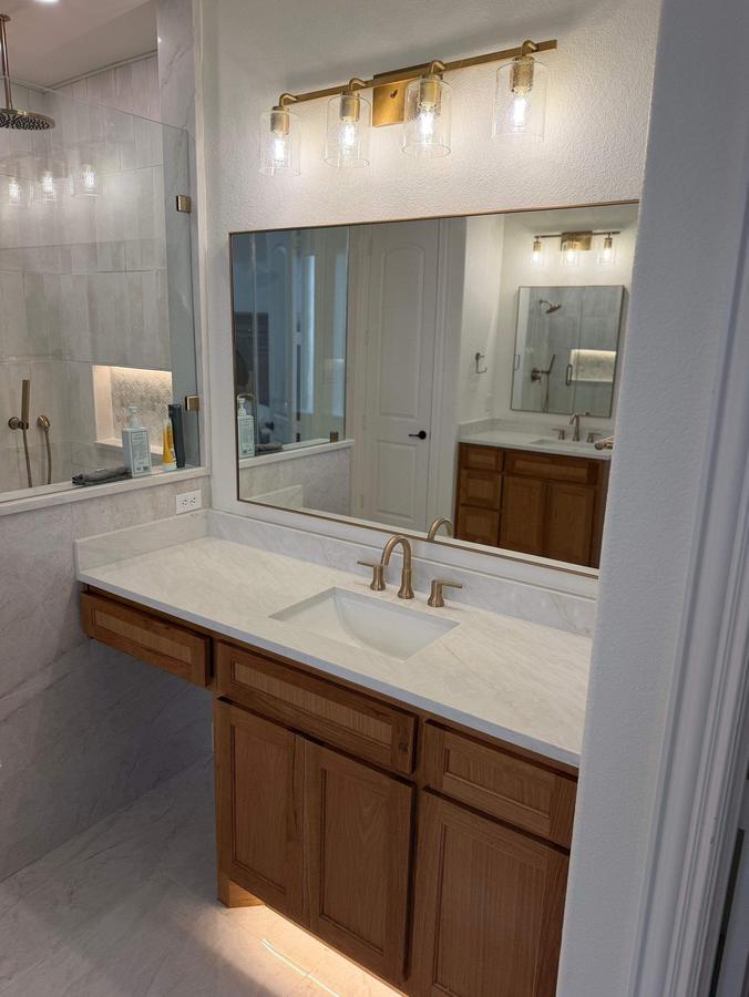 Wood vanity with quartz top and brass fixtures